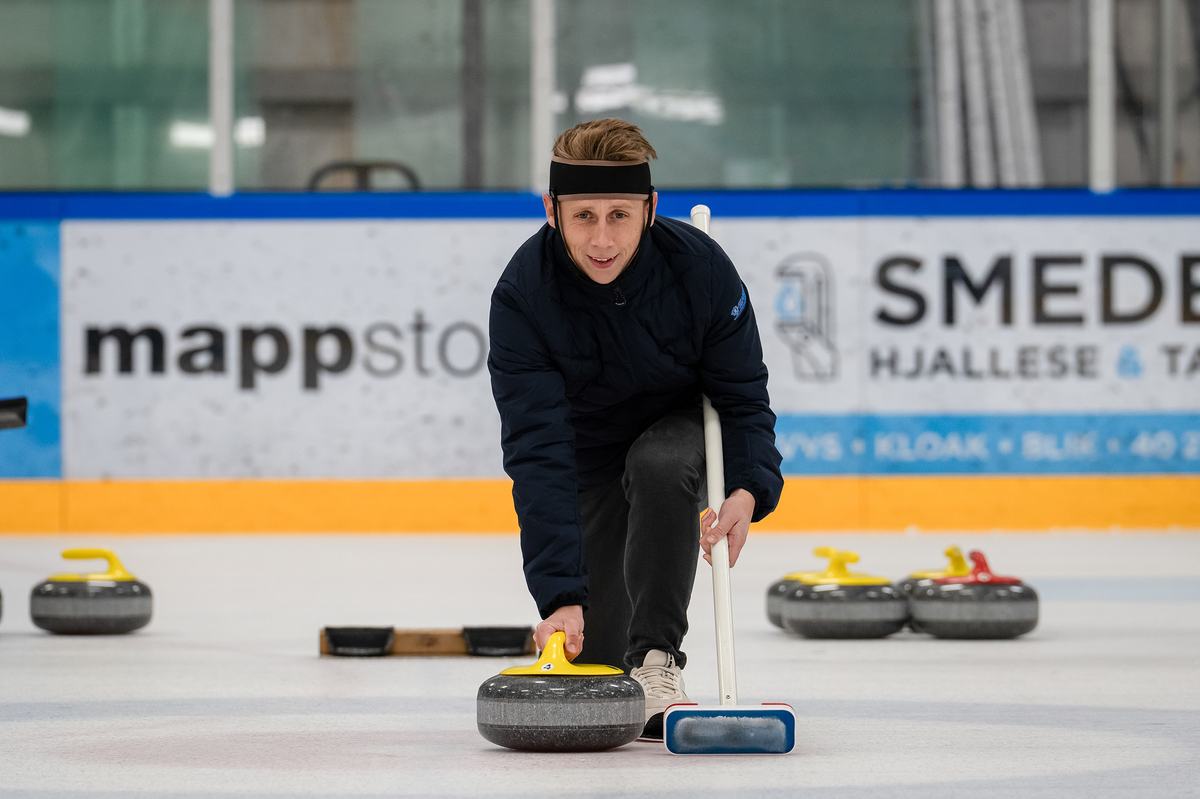 Medlem sender en curlingsten af sted