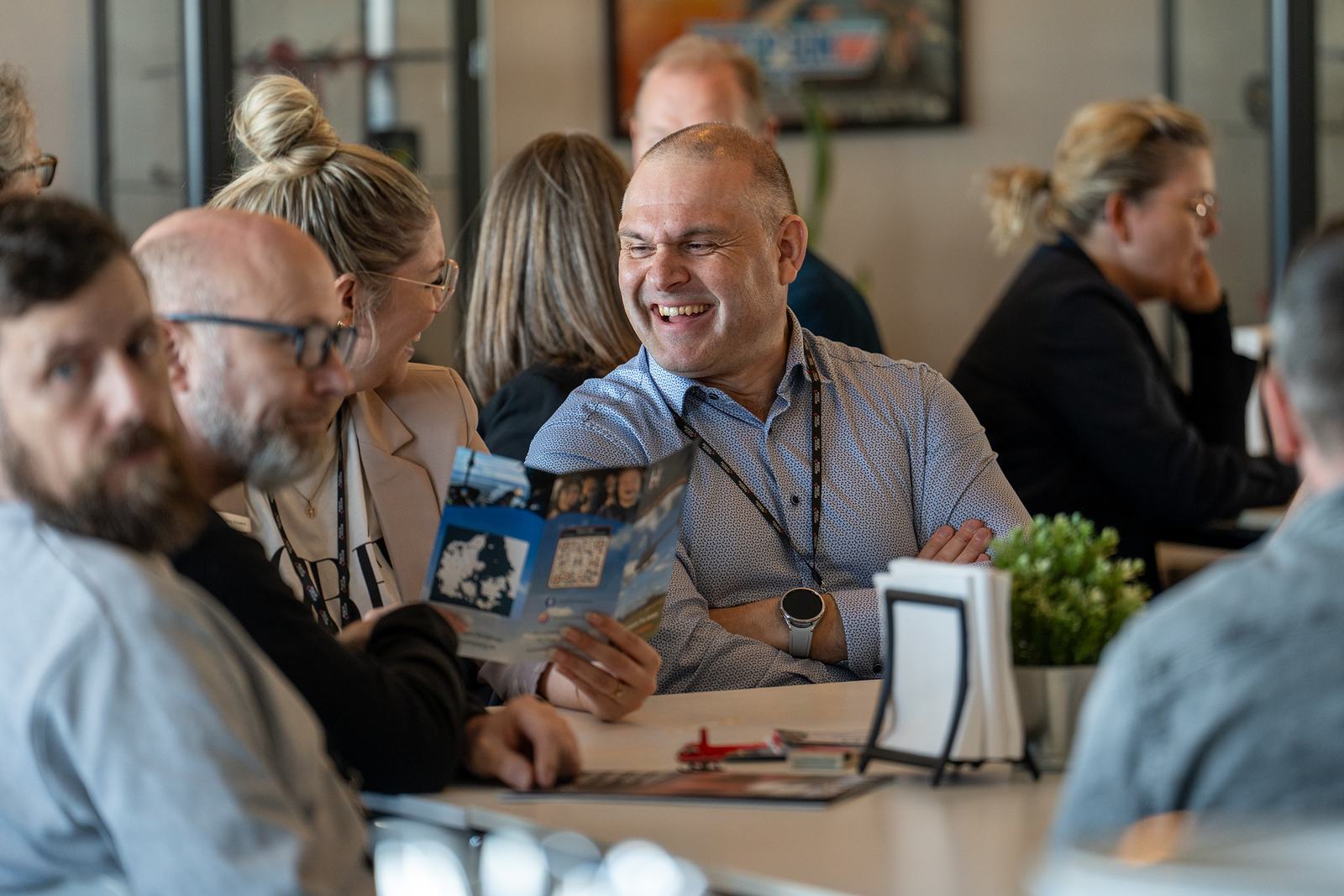 Medlem griner med en brochure i hånden