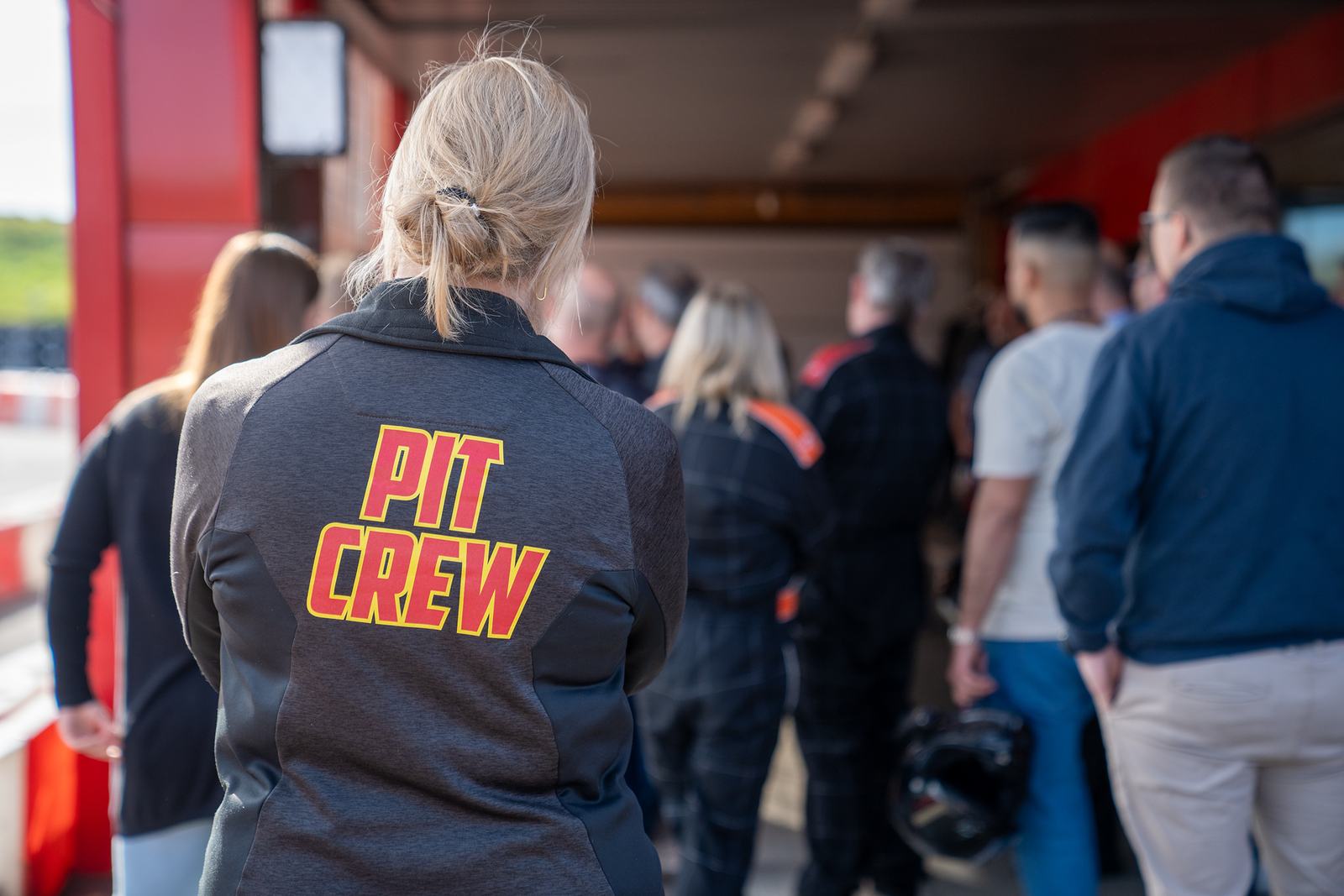 Medlem i Pit Crew-jakke ved banen
